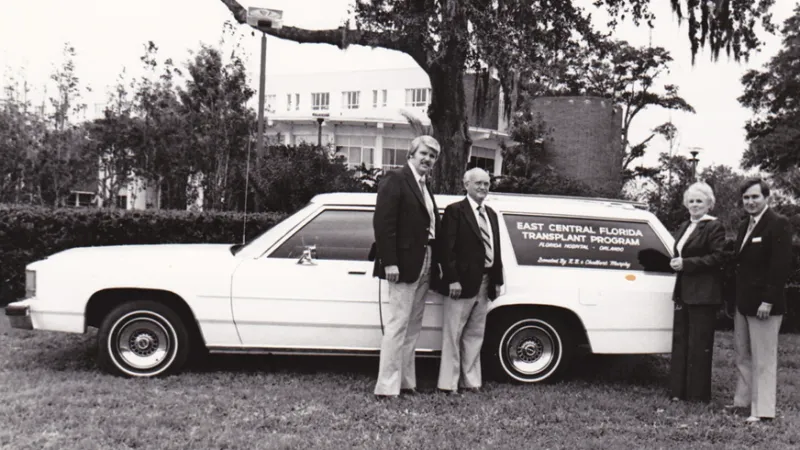 In the 1970s, the first organ procurement automobile was gifted to AdventHealth to help transport kidney donations. Organ procurement coordinators gather around the new vehicle with the generous community members who made the gift. (Dr. Metzger is not pictured.)