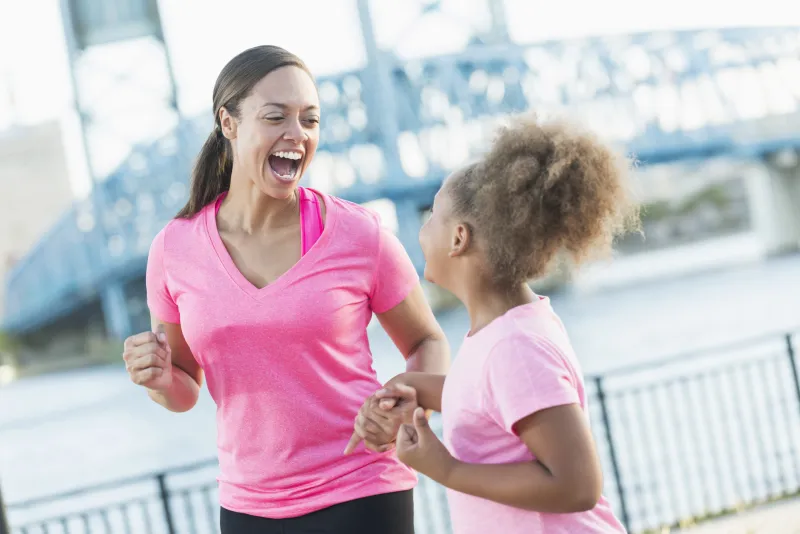 Mother and daughter holding hands for pink run