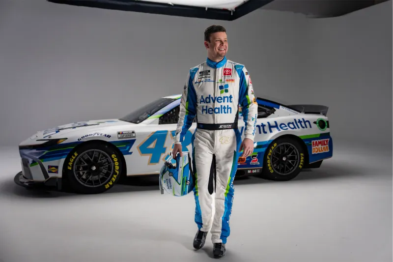 Erik Jones stands in front of his NASCAR vehicle.