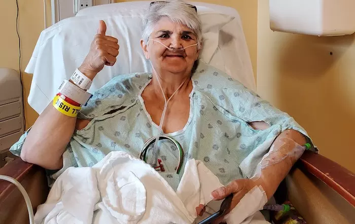 Patient Carol Dunn giving a thumbs up after her surgery.