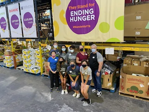 A group of volunteers in front of boxes of donated food